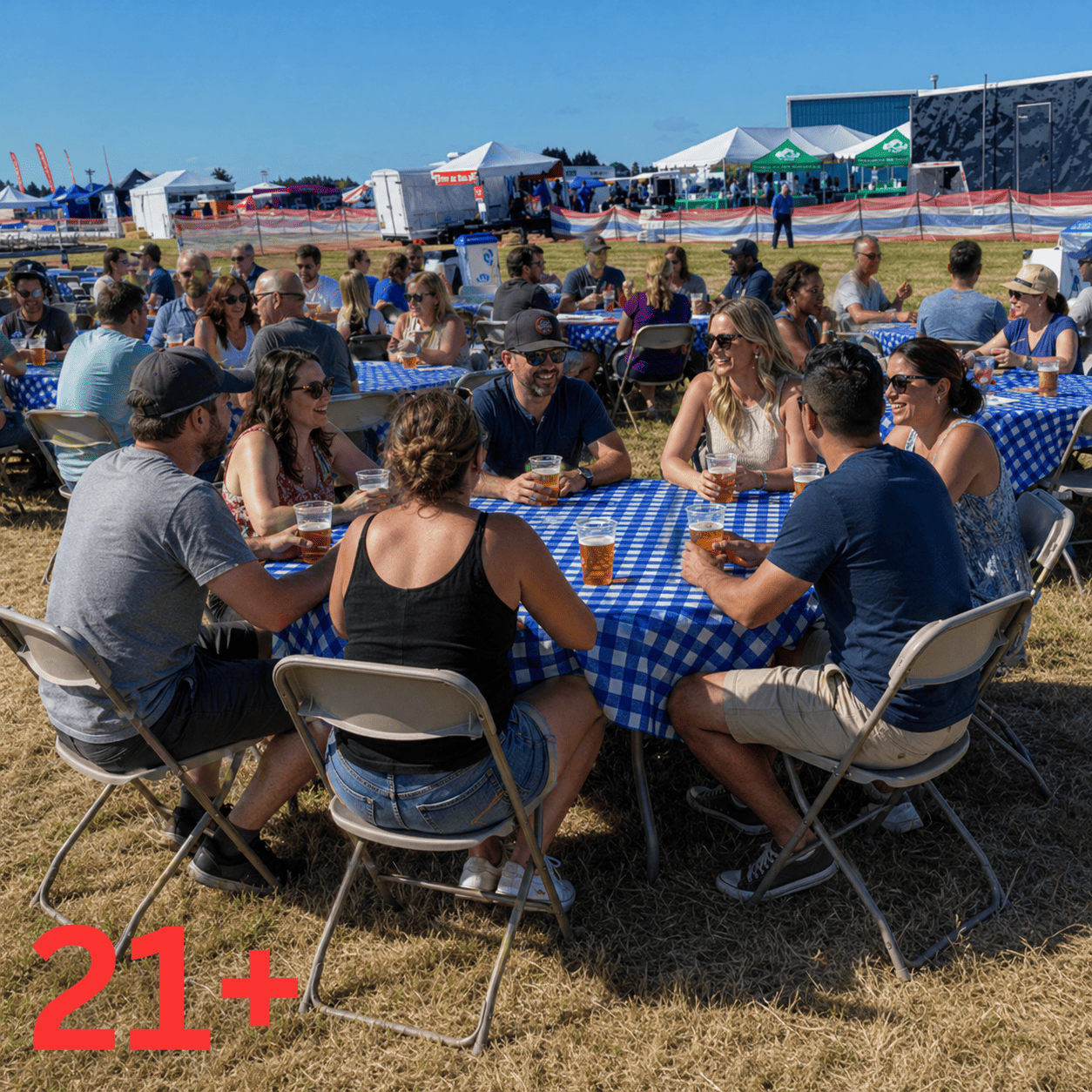 Oregon International Air Show - Ticket Type Beer Garden. Adults sit at tables with checkered table cloths, each with a beer.  The air show grounds are off in the distance. 